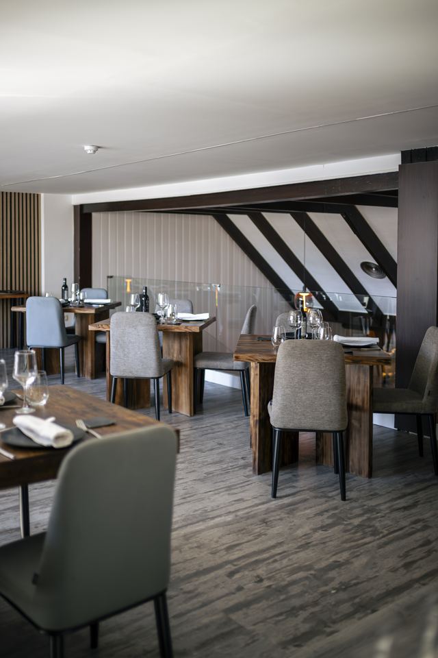 Salón privado con vigas oscuras y mesas de madera preparadas