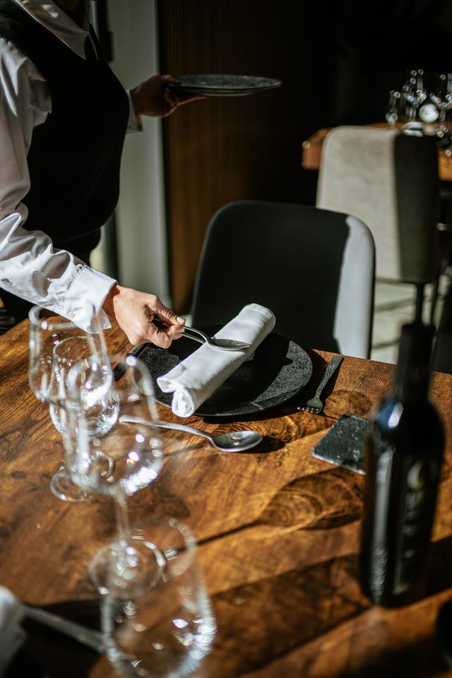 Camarero preparando una mesa con copas y servilleta