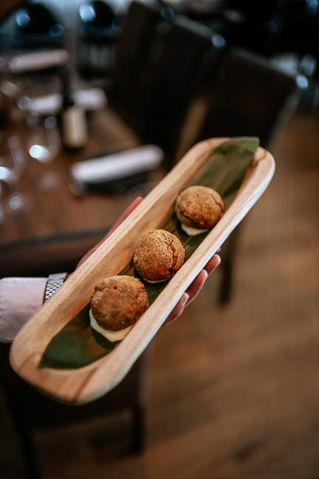 Croquetas servidas en una bandeja alargada de madera